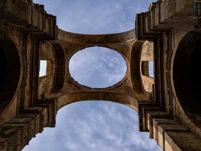 Due finestroni inseriti in due larghi archi in pietra sono infine sovrastati da quella che un tempo era la cupola di forma ellissoidale. Di fatto la cornice che delimitava la copertura � l�unica parte rimasta in piedi del tetto di una chiesa che per�, da secoli, guarda poeticamente verso il cielo, aprendosi alla vastit� dell�azzurro
